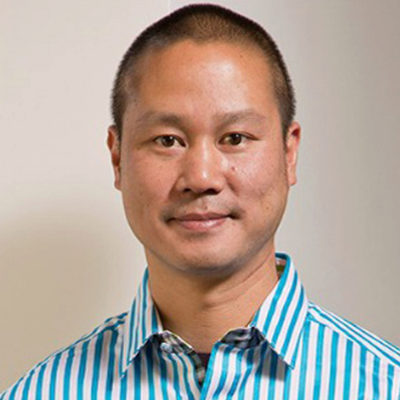 A headshot of a person wearing a blue and white striped shirt against a neutral background.