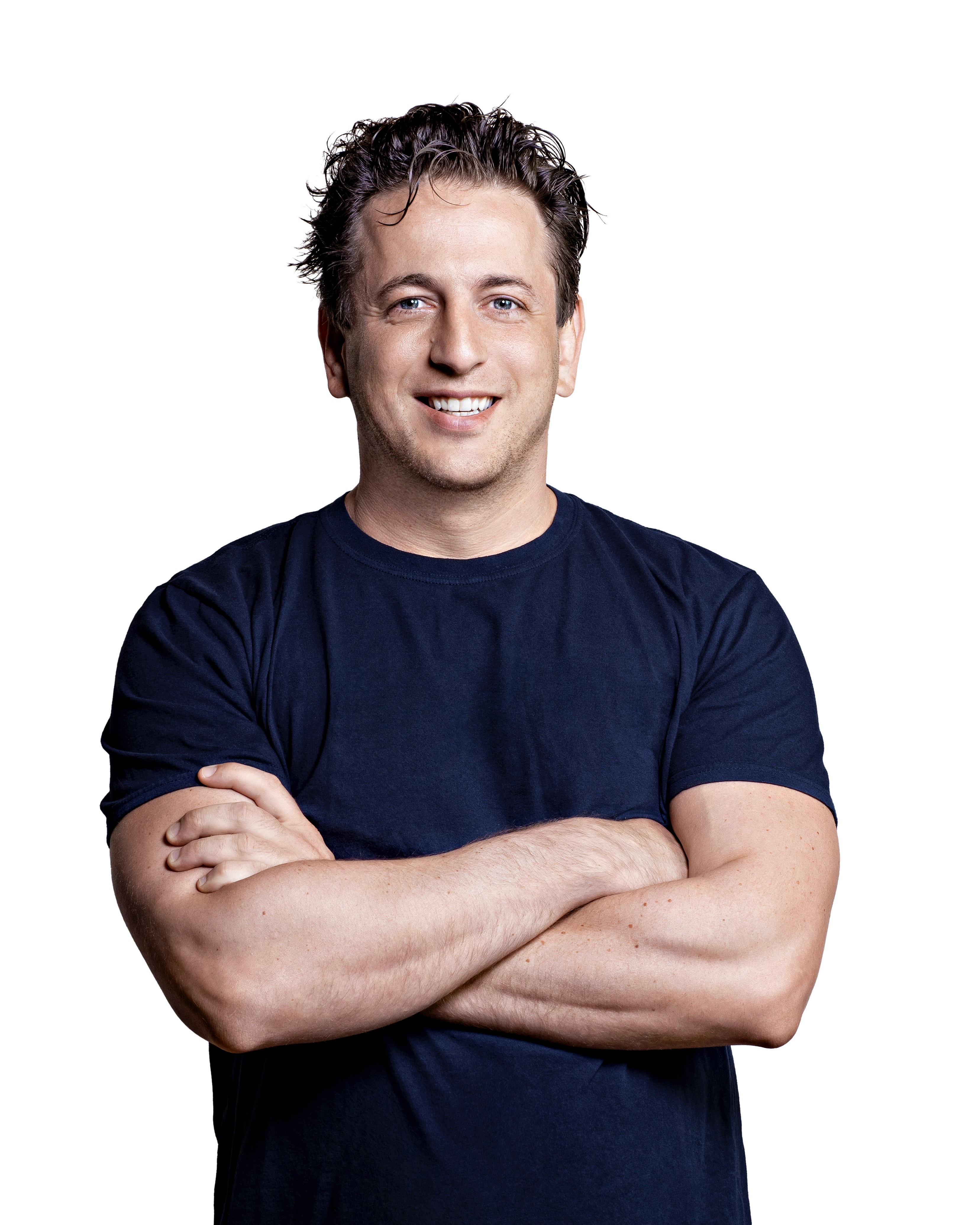 A person smiling with arms crossed, wearing a navy blue t-shirt, against a plain white background.